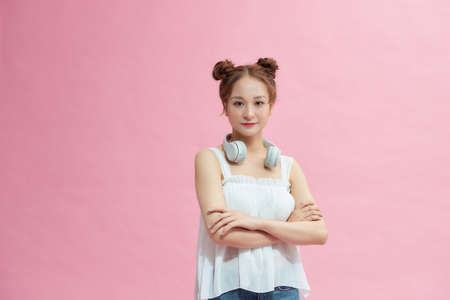 Casual woman smiling with arms crossed - isolated over pinkの写真素材