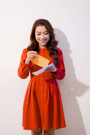 Happy beautiful girl holding greeting card and smiling joyfullyの写真素材
