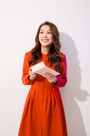 smiling beautiful young woman holding a valentine's day postcard with red heart , valentines day , isolated on white backgroundの写真素材