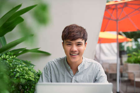 Young freelancer working on laptop in coffeeの写真素材