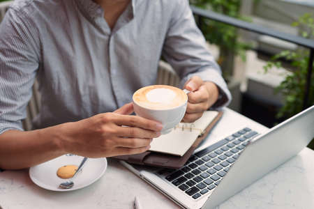 Young asian economist using laptop in coffee shopの写真素材