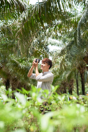 Young hipster photographer with retro film photo cameraの写真素材