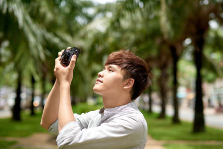 Young hipster photographer with retro film photo cameraの写真素材