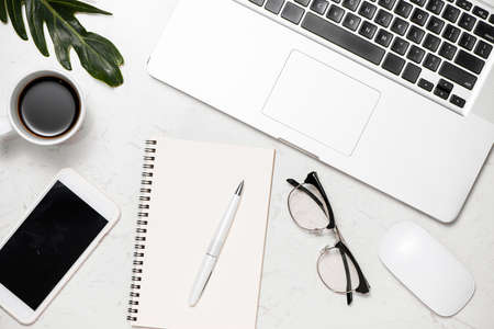 Top view photo of workplace white keyboard mouse open spiral notebook cup of coffee binder clips and...