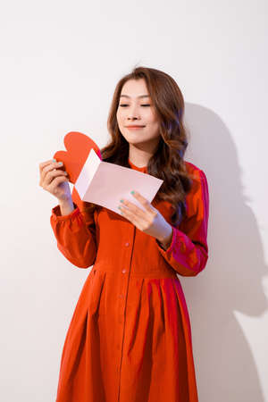 Smiling Woman Holding a Red Heart and an Envelopの写真素材