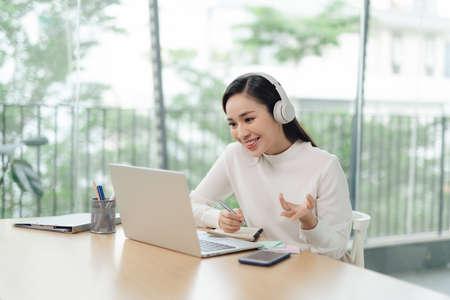 A young female student sitting at the table, using tablet when studying.の写真素材