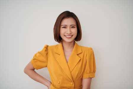 smiling Asian woman against white  wallの写真素材