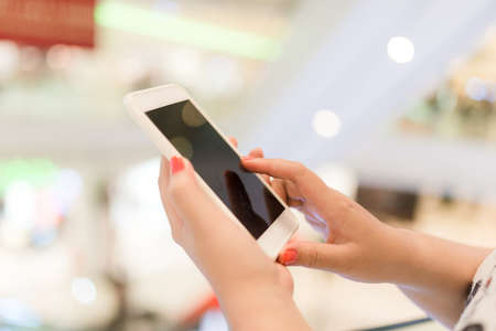 Hands using mobile smart phone and take a photo in display view of a clothing store, shopping online...