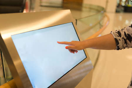 Woman using interactive touchscreen display at urban exhibition - scrolling and touching. Education...