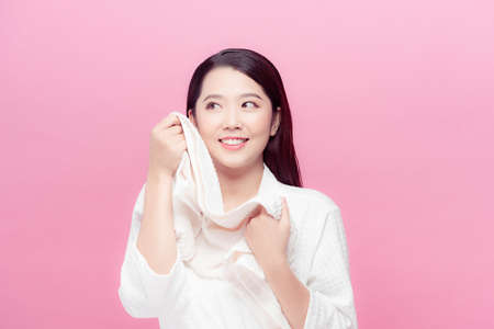 Woman wiping facial skin with towel after washing face, removing makeup.の写真素材