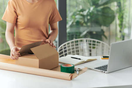 Private business concept. A woman working with packing box for delivery in home-office.の写真素材