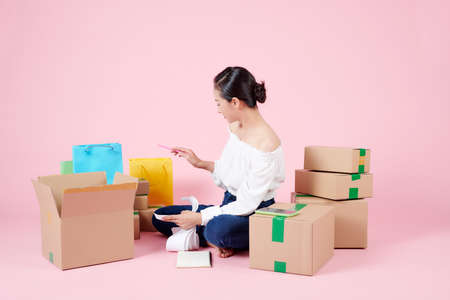 Young woman with cardboard box at home - Business online and delivery conceptの写真素材