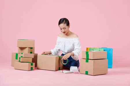 Woman packing item that she sells online.の写真素材
