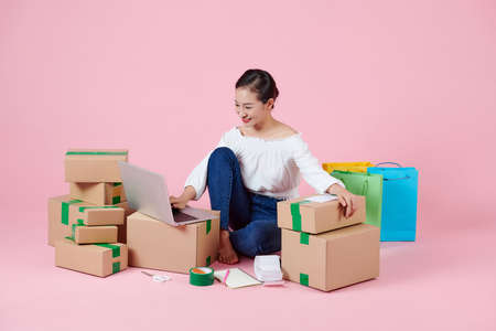 woman working at home office packaging on backgroundの写真素材