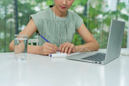 Smiling businesswoman teleconferencing from homeの写真素材