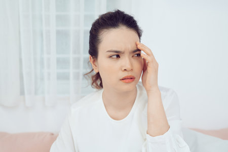 Asian woman feeling unwell and sneeze on bedの写真素材