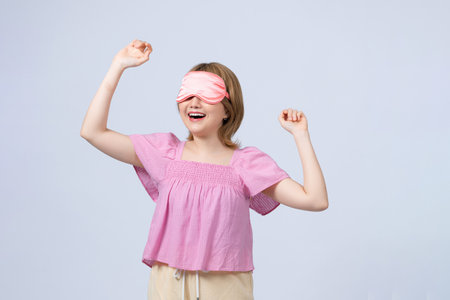 Young woman with sleep mask isolated on white backgroundの写真素材