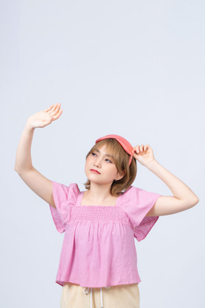 Photo portrait of pretty woman stretching isolated on gray backgroundの写真素材