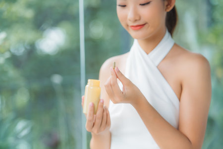 Beautiful Smiling Girl Taking Medication, Holding Bottle With Pills In Hand.の写真素材