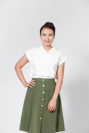 Portrait of young asian woman standing with hands on waist and looking at cameraの写真素材