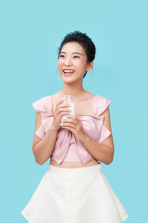 Young woman is drinking milk. Healthy nutrition.の写真素材
