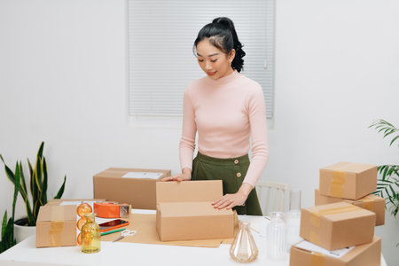 Women packing package with her products that she selling onlineの写真素材