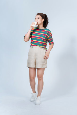 a girl likes to drink milk to stay healthy with a glassの写真素材