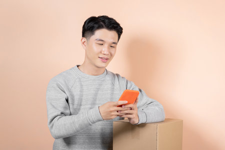 Asian man online seller confirming orders from customer on the phoneの写真素材