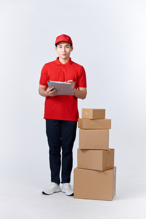 Male employee in cap t-shirt print working as courier dealer hold empty cardboard boxの写真素材
