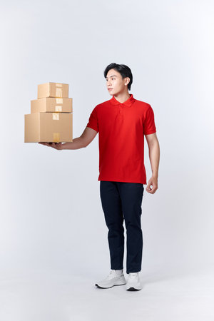 Delivery man in red uniform isolated on white background, studio portrait.の写真素材