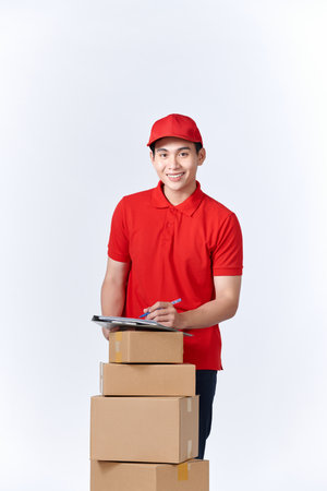 Asian delivery man or passenger holding a cardboard box ready to delivery isolated with clipping path and copy space on white background.の写真素材