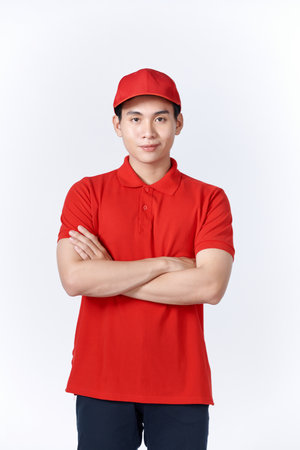 Professional smiling confident male employee in cap, t-shirt courier dealer holding hands crossed foldedの写真素材