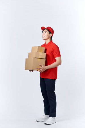 Young asian man holding delivery package smiling happy and positiveの写真素材