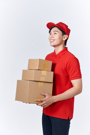 Delivery man in red uniform isolated on white background, studio portrait.の写真素材