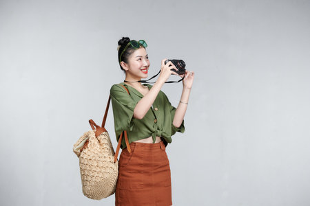 Excited young cheerful female tourist holding photo cameraの写真素材