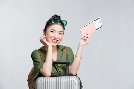 Portrait of nice smiling woman holding passport and flying ticketsの写真素材