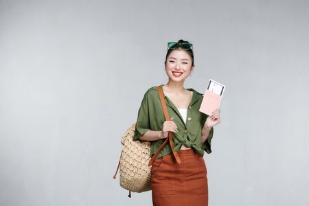 Portrait of happy tourist woman holding passport on holiday on white backgroundの写真素材
