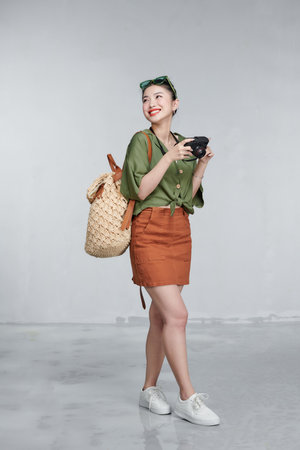 Beautiful young female traveler with camera and backpackの写真素材