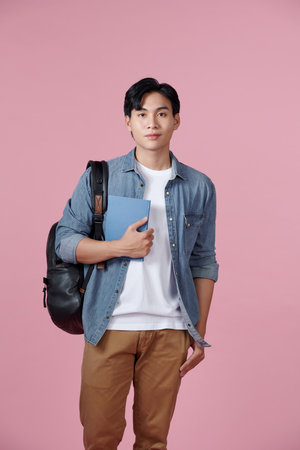 happy smiling student standing with backpack and folders over pink backgroundの写真素材