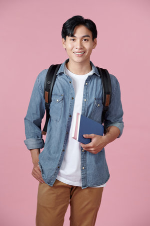 happy smiling student standing with backpack and folders over pink backgroundの写真素材
