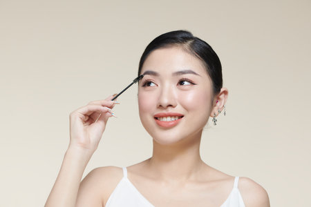 Young girl using brush for eyebrows.の写真素材