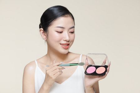 Portrait of stylish trendy modern girl with beaming smile gesturing new quality shadow having palette and brush in handsの写真素材