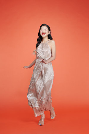 Carefree smiling woman in glamorous outfit dancing at partyの写真素材