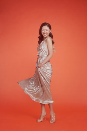 Studio shot of a beautiful young woman in a silver sequined dress dancing.の写真素材