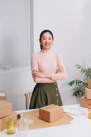 Asian businesswoman standing with her arms crossed and smiling for the camera.の写真素材