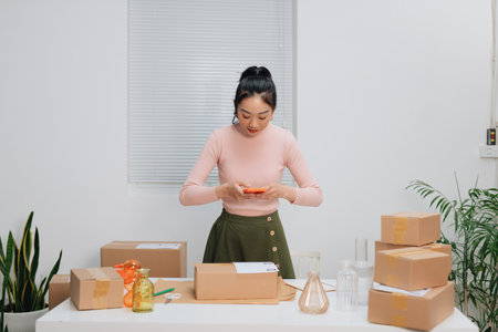 Young beautiful woman checking a parcel, with smiling look happy with her jobの写真素材