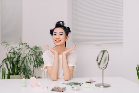 Close up smiling young woman wearing white t-shirt doing facial massageの写真素材