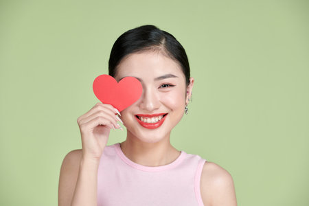Valentine's Day. Beautiful young woman with heart in her hands.の写真素材