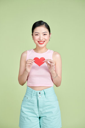 Woman holding paper heart shaped cardの写真素材