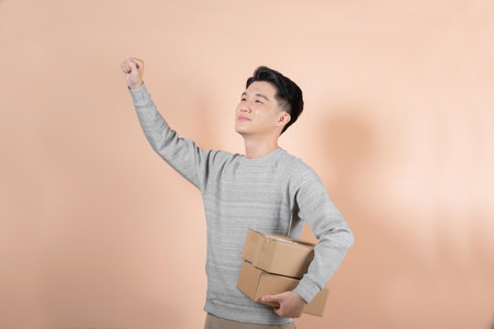 handsome man in a gray hoodie shirt with parcelの写真素材